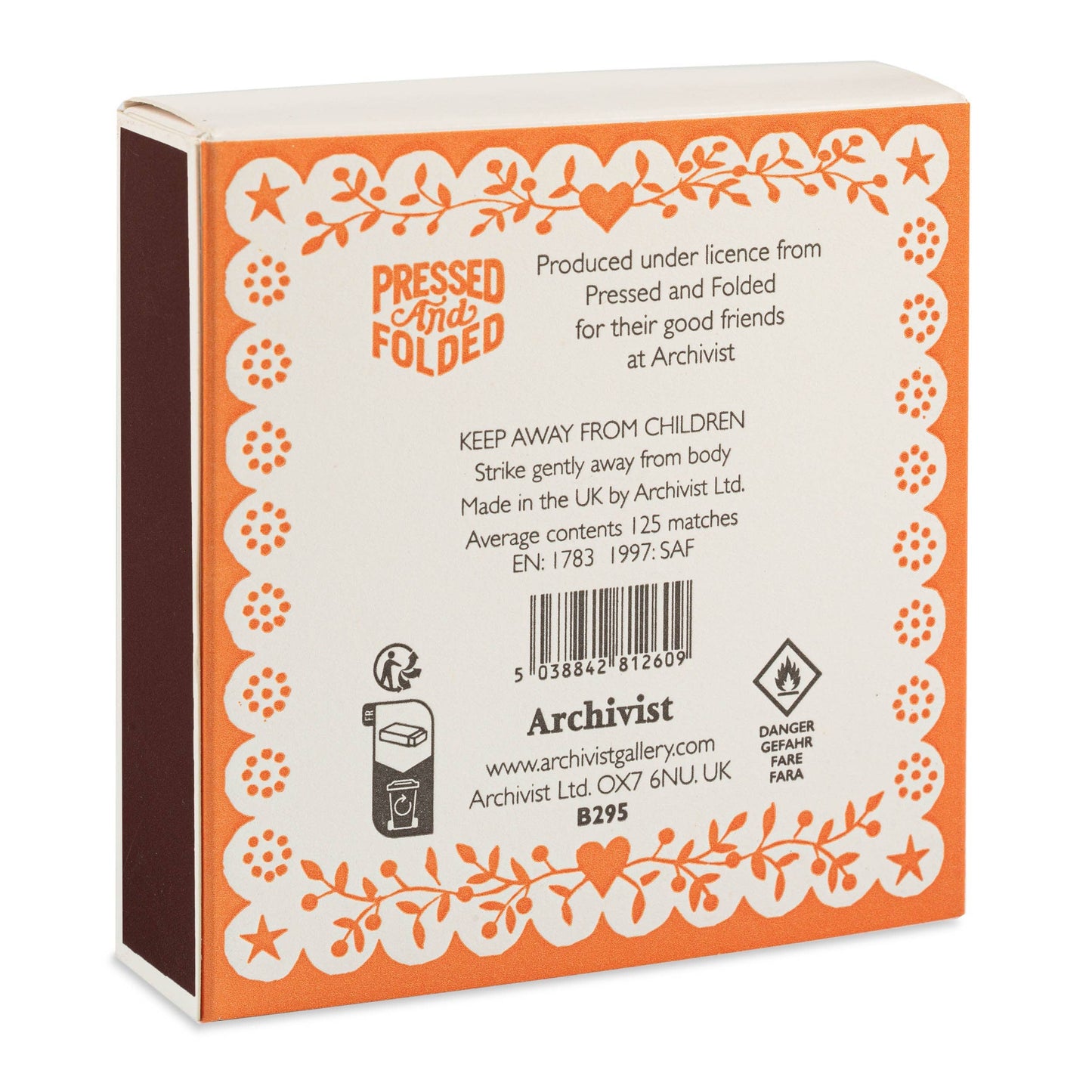 Die Archivist Gallery | Bright Spark quadratische Streichholzschachtel ist mit einer orangefarbenen, floralen Linolschnitt-Bordüre, einem Sicherheitstext, einem Strichcode, Herstellerangaben und einem Flammenschutzsymbol auf der Rückseite versehen. Oben steht "Pressed and Folded".