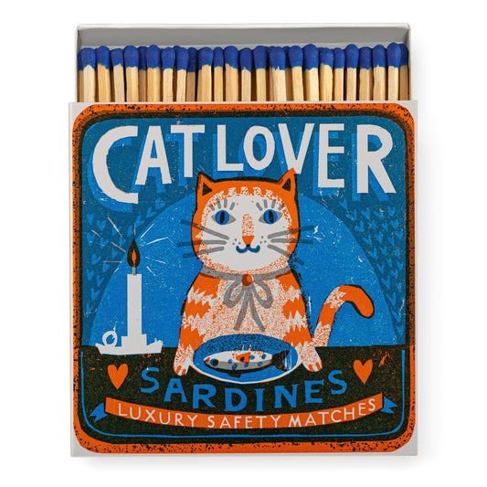 The Archivist Gallery - Katzenliebhaber Sardinen Quadrat-Sicherheitsstreichhölzer ist eine Streichholzschachtel mit einer orangefarbenen Katze, Sardinen und Kerzenmotiv. Im Inneren befinden sich Streichhölzer mit blauer Spitze - ideal für jeden Katzenliebhaber.