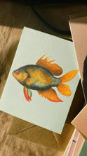 Lade das Bild in den Galerie-Viewer, Die 30x40 Goldfisch-Minikarte zeigt eine orange, gelbe und dunkelgraue Goldfisch-Illustration, ist lokal auf Recyclingpapier gedruckt und wird mit einem braunen Umschlag geliefert.
