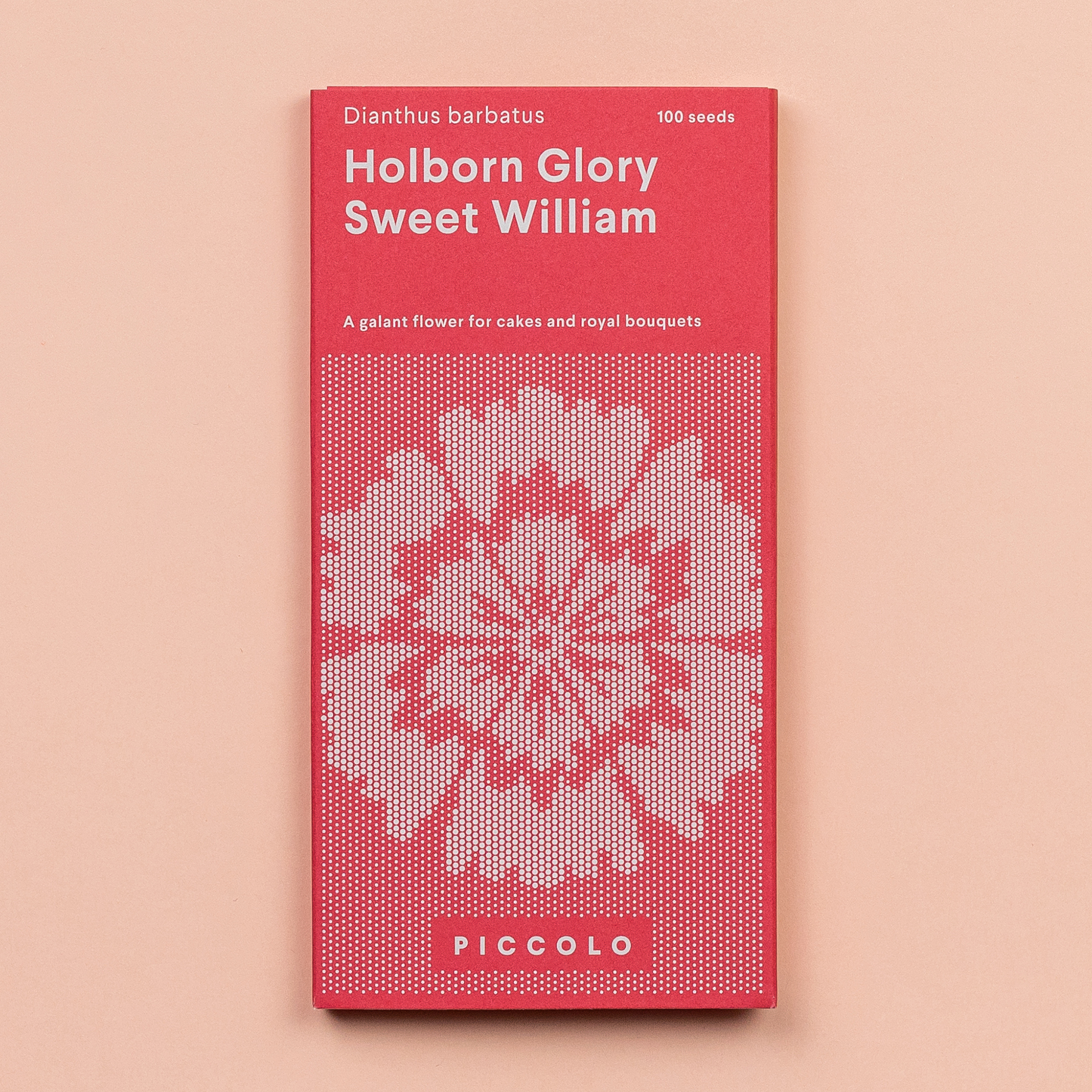 Eine rot-rosa Saatgutpackung mit der Aufschrift Piccolo Seeds - Der süße William Holborn Glory zeigt ein geometrisches Blumenmuster, Dianthus barbatus, essbare Blütenblätter, 100 Samen und die Marke Piccolo Seeds auf einem hellen pfirsichfarbenen Hintergrund.