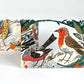 Zwei illustrierte Art Angels - Collage-Karte zum Winterfest - Mark Hearld Pop-up-Karten zeigen bunte Vögel und grünes Laub, wobei eine Karte ein Rotkehlchen im Vordergrund zeigt und die andere verschiedene Vogelarten darstellt.