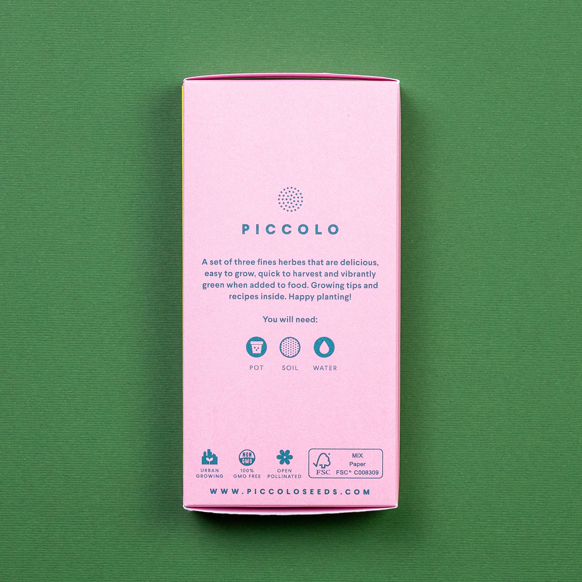 Eine Piccolo Seeds - Küchenkräuter Packung von Piccolo Seeds steht auf einem grünen Hintergrund. Die rosafarbene Packung enthält Symbole für Topf, Erde und Wasser, den Hinweis, dass sie gentechnikfrei ist, und eine Pflanzanleitung sowie Informationen zur Website am unteren Rand.