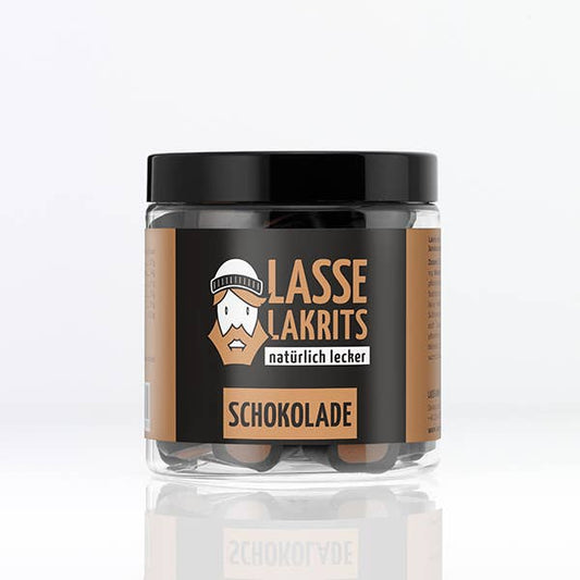 Die LASSE LAKRITS Dose Lakritz Schokolade aus klarem Kunststoff mit schwarzem Deckel zeigt ein Cartoon-Gesicht mit Hut und "natürlich lecker" auf einem braun-schwarzen Etikett der Marke LASSE LAKRITS.