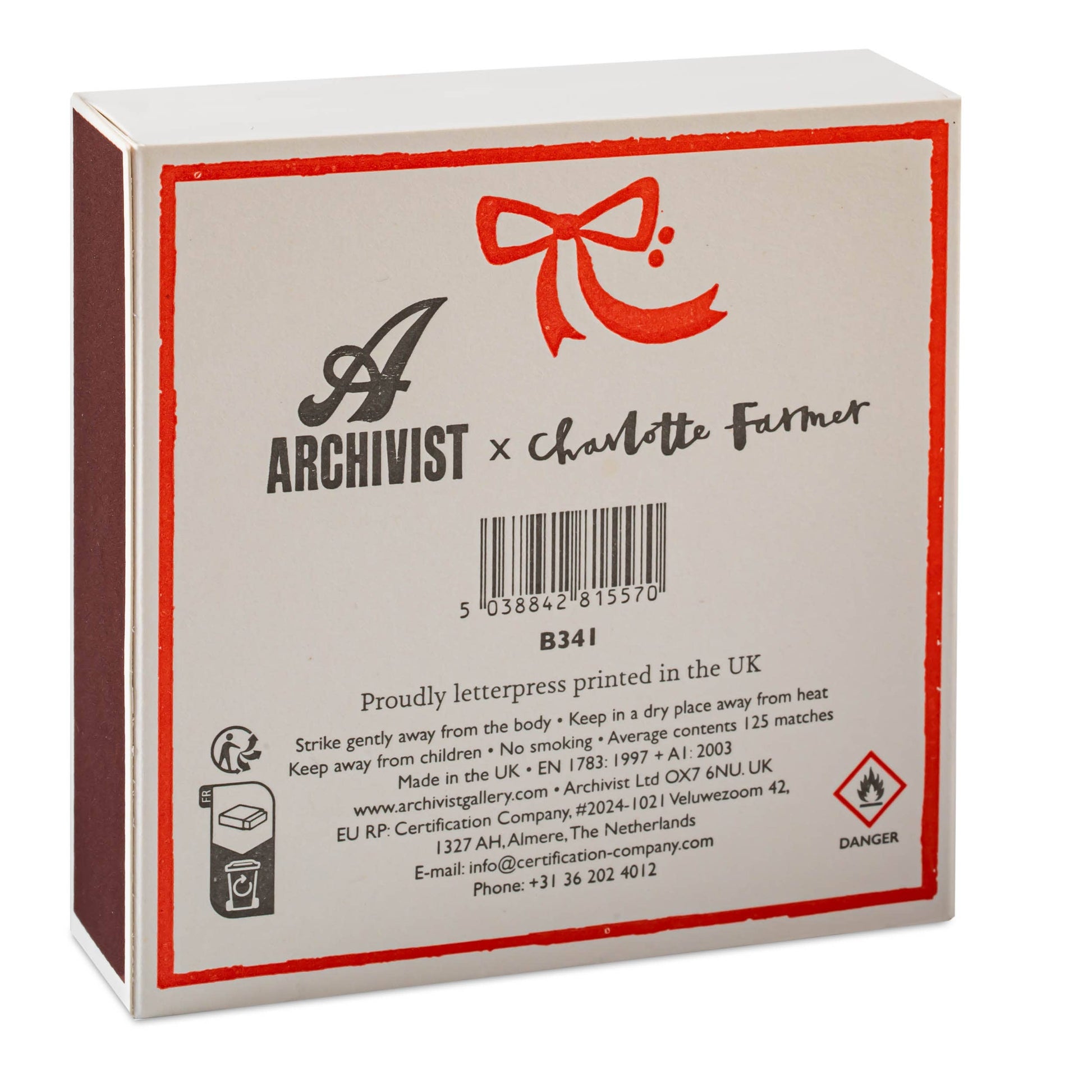 Auf der Rückseite des Archivist Gallery | Europe - Pudel Quadrat Weihnachts-Sicherheitsstreichhölzer🎄 befinden sich ein Branding, Sicherheitsinformationen, eine rote Schleife und ein Gefahrensymbol - ein ideales besonderes Streichhölzer oder ein festliches Geschenk für jeden Pudel-Fan.