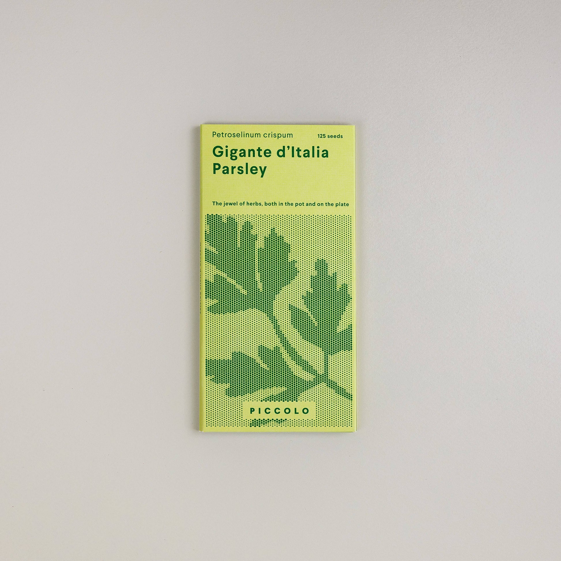 Eine Packung Piccolo Seeds – Petersilie Gigante d'Italia von Piccolo Seeds, mit 125 Samen und einem grünen Design mit einem illustrierten Petersilienblatt, ideal für den Herbstanbau, dargestellt vor einem schlichten hellen Hintergrund.