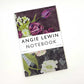 Das Art Angels Notizbuch von Angie Lewin zeigt ein florales Cover mit Tulpen und Narzissen auf einem dunklen, gemusterten Hintergrund. Es bietet unbedruckte Seiten und ist damit ideal für Notizen oder Skizzen.