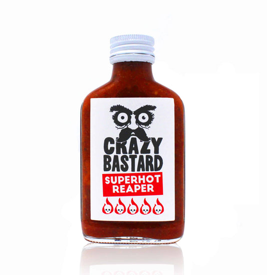 Die 100-ml-Flasche der CBS Foods GmbH (Crazy Bastard Sauce) Superhot Reaper scharfe Soße, hergestellt mit Carolina Reaper Chili, hat ein weißes Etikett mit fettgedrucktem Text, schwarzen grafischen Augen und Schnurrbart sowie fünf Flammen für intensive Schärfe.