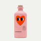 Die pinkfarbene 500-ml-Flasche Natives Olivenöl - Love Edition von yiayia and friends mit Holzkappe zeigt ein großes rotes Herz mit Cartoon-Augen und "Organic Extract 500 mg". Limitierte Auflage - perfekt für Salate.
