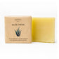 Ein hellgelber Aloe Vera Seifenriegel von maisoap berlin liegt neben einer braunen Schachtel mit einem Aloe-Motiv und deutschem Text, der darauf hinweist, dass es sich um eine handgefertigte Gesichtsseife mit natürlichen Inhaltsstoffen handelt.