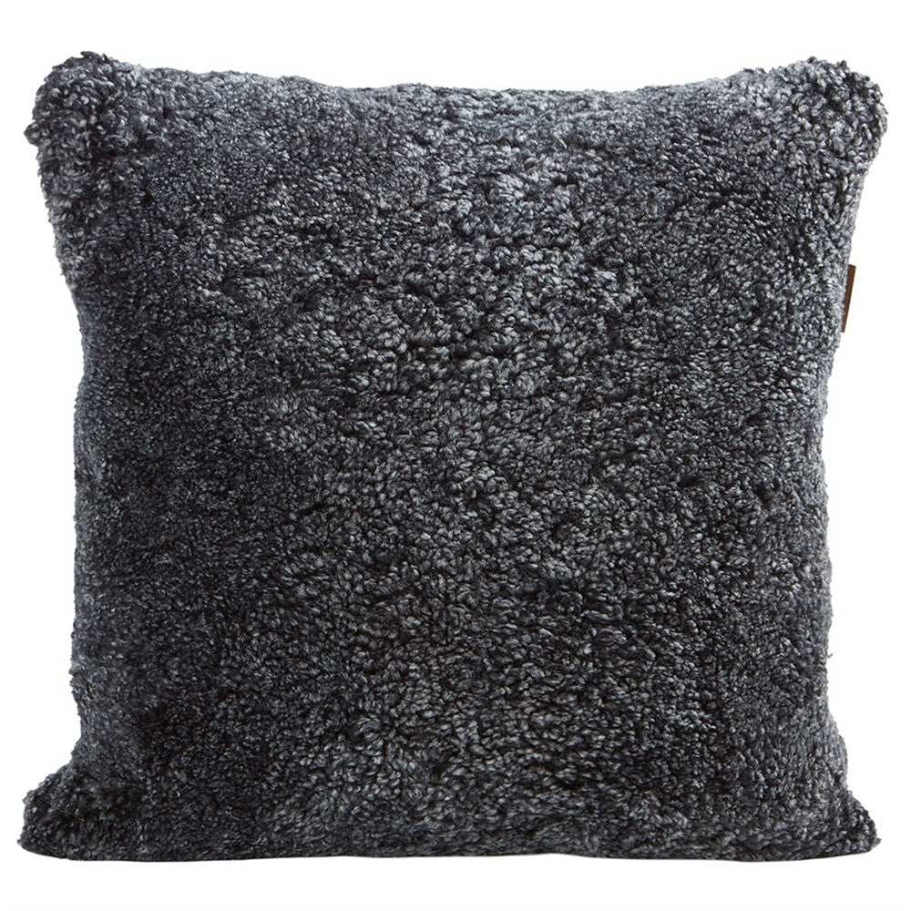 Der Alice Kissenbezug aus Schafsfell in Graphit (50x50) von Shepherd of Sweden sorgt mit seinem weichen, gelockten Schaffell für skandinavische Gemütlichkeit. Hier abgebildet vor einem weißen Hintergrund.