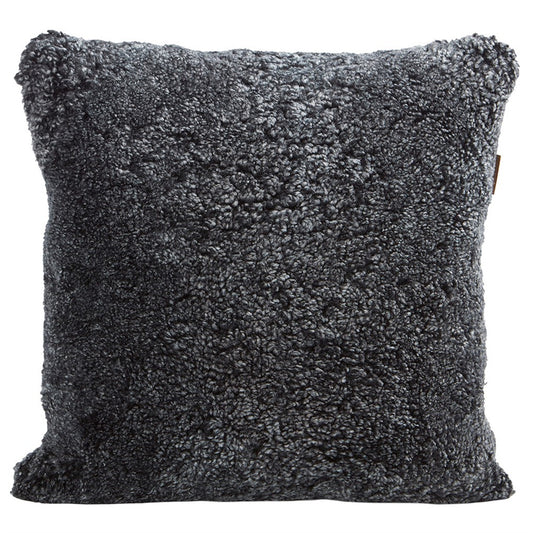 Der Alice Kissenbezug aus Schafsfell in Graphit (50x50) von Shepherd of Sweden sorgt mit seinem weichen, gelockten Schaffell für skandinavische Gemütlichkeit. Hier abgebildet vor einem weißen Hintergrund.