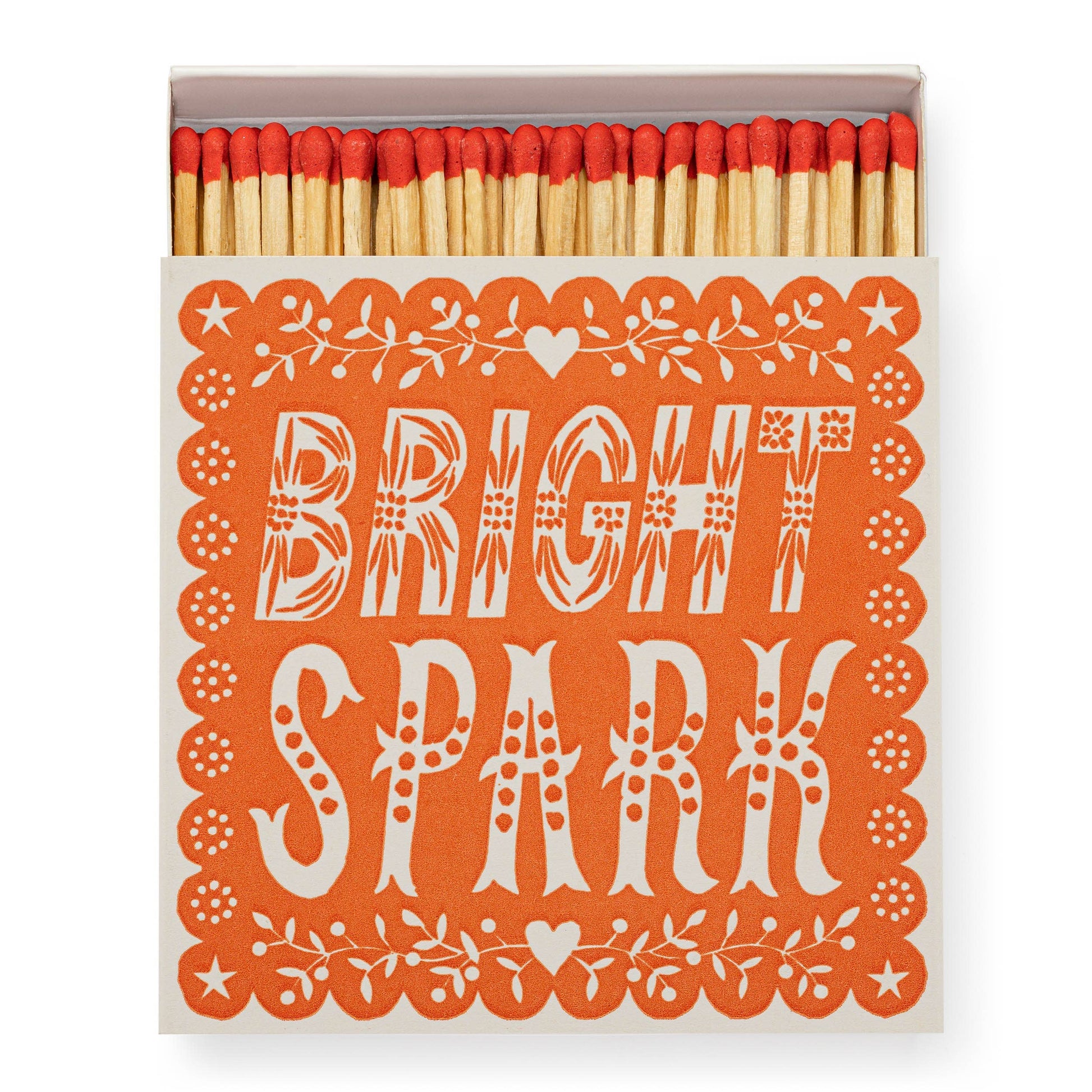 Die Archivist Gallery | Bright Spark | Quadratische Streichholzschachteln zeigt rote Streichhölzer in einer orangefarbenen Schachtel mit weißen Blumenmustern und dem Schriftzug "BRIGHT SPARK", der an ein von Linolschnitt inspiriertes Design erinnert. Marke: Archivist Galerie.