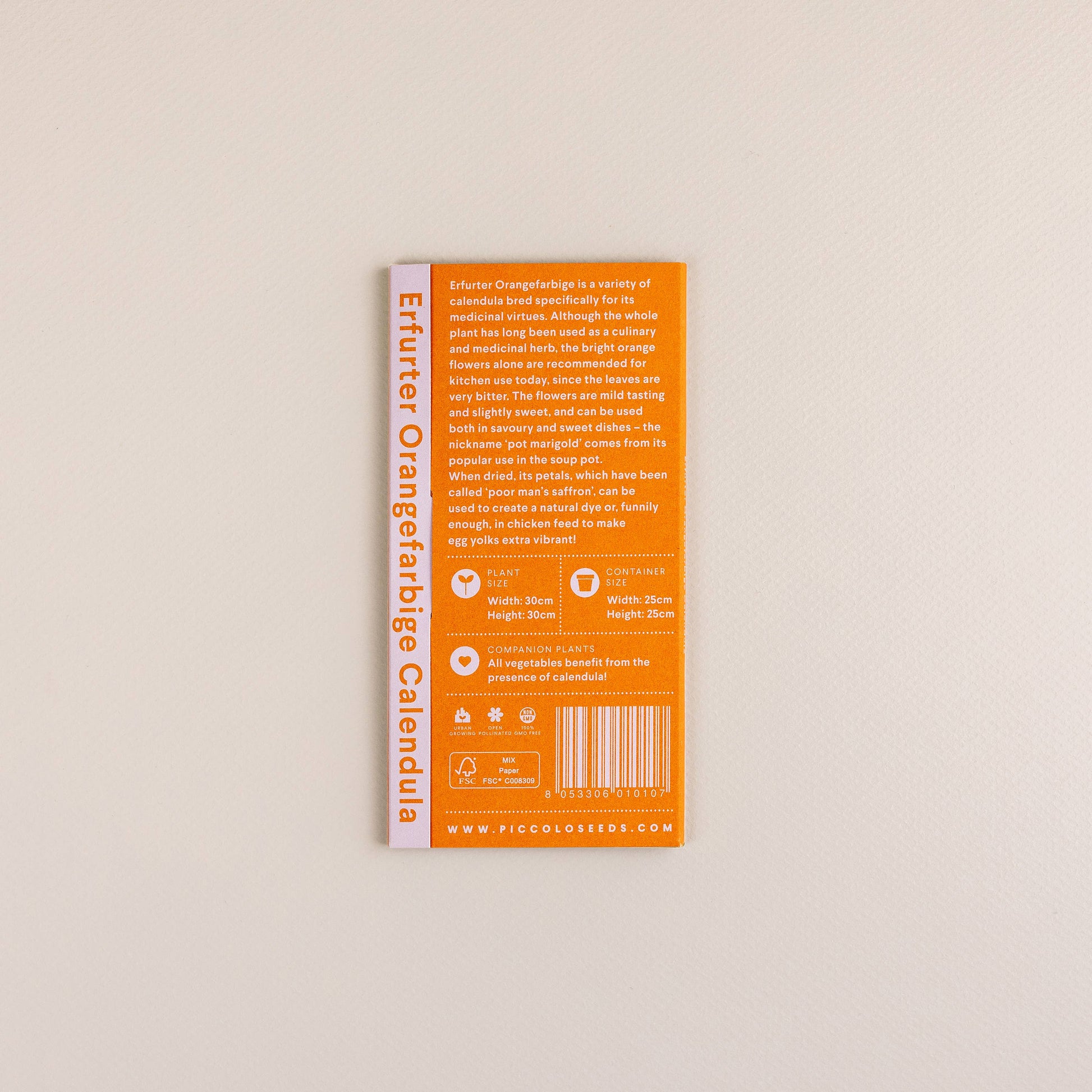 Eine rechteckige orangefarbene Piccolo Seeds-Packung mit der Aufschrift "Ringelblume Erfurter Orangefarbene" mit weißem und gelbem Text, Symbolen und Website-Link liegt auf einer hellen, strukturierten Oberfläche.