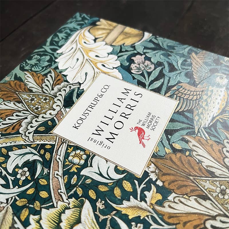 Eine Nahaufnahme des Koustrupco Seidenschal Morris Pimpernel Blau 50 x 50 cm zeigt verschlungene grüne, goldene und weiße Blumen- und Vogelmuster, die von William Morris' Stil für die William Morris Society inspiriert sind.