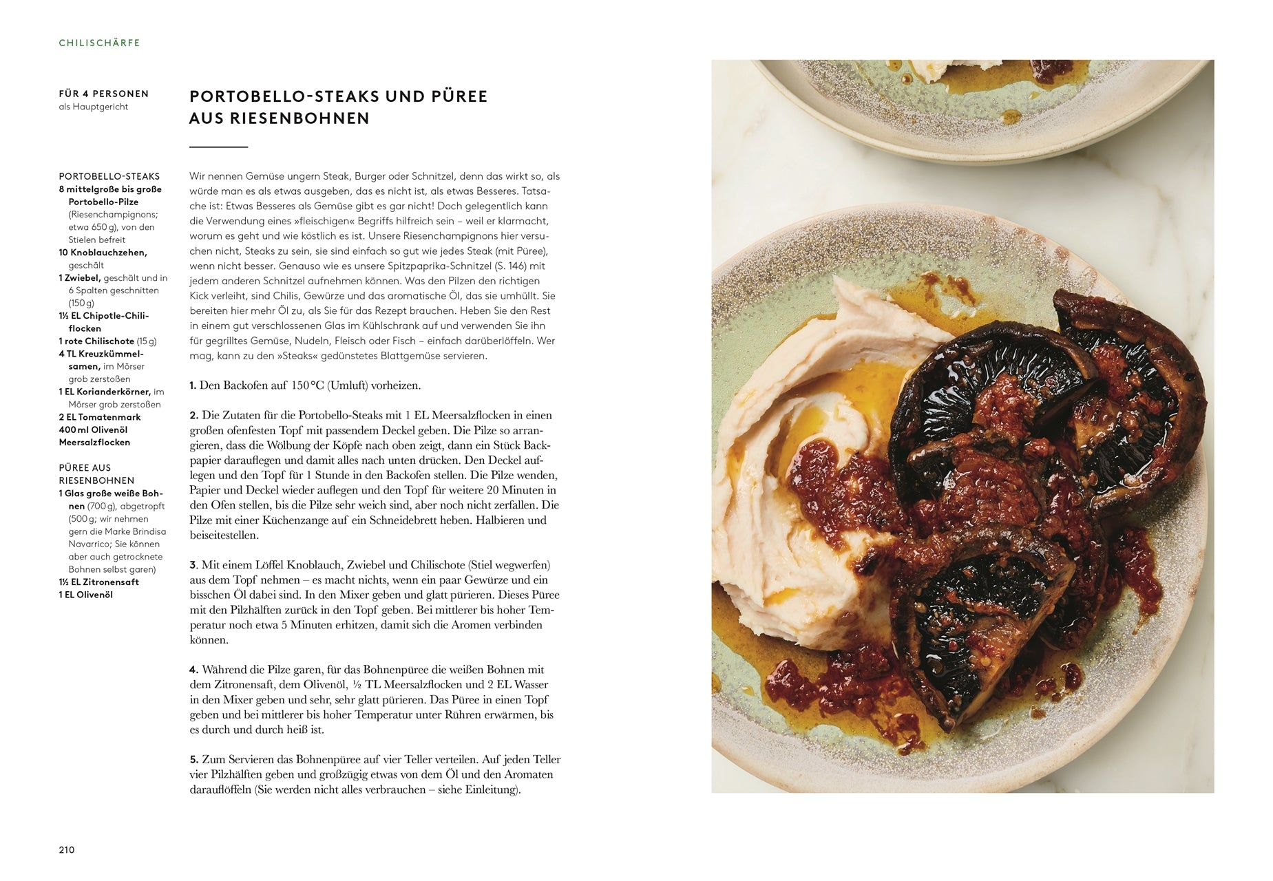 Ein Teller mit Flavour vom DK Verlag mit gegrillten Portobello-Pilzen, weißem Bohnenpüree und Tomaten-Chili-Sauce - ideal für Fans von veganen Rezepten - liegt auf Marmor neben einem anderen Teller mit demselben Gericht.