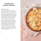Ein goldbrauner, runder Apfelkuchen mit arrangierten Scheiben sitzt in einer mit Pergament ausgelegten Form - die perfekte vegane und glutenfreie Wahl, inspiriert von "Kleine Kuchen" aus dem DK Verlag.