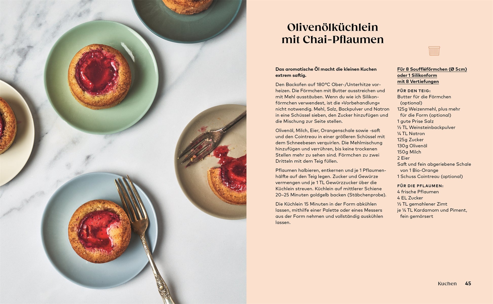 Vier Kleine Kuchen mit Pflaumenkernen werden auf pastellfarbenen Tellern um eine Gabel auf Marmor serviert. Rechts ein Auszug aus einem Kochbuch des DK Verlags mit dem Rezept für diese köstlichen Leckereien.