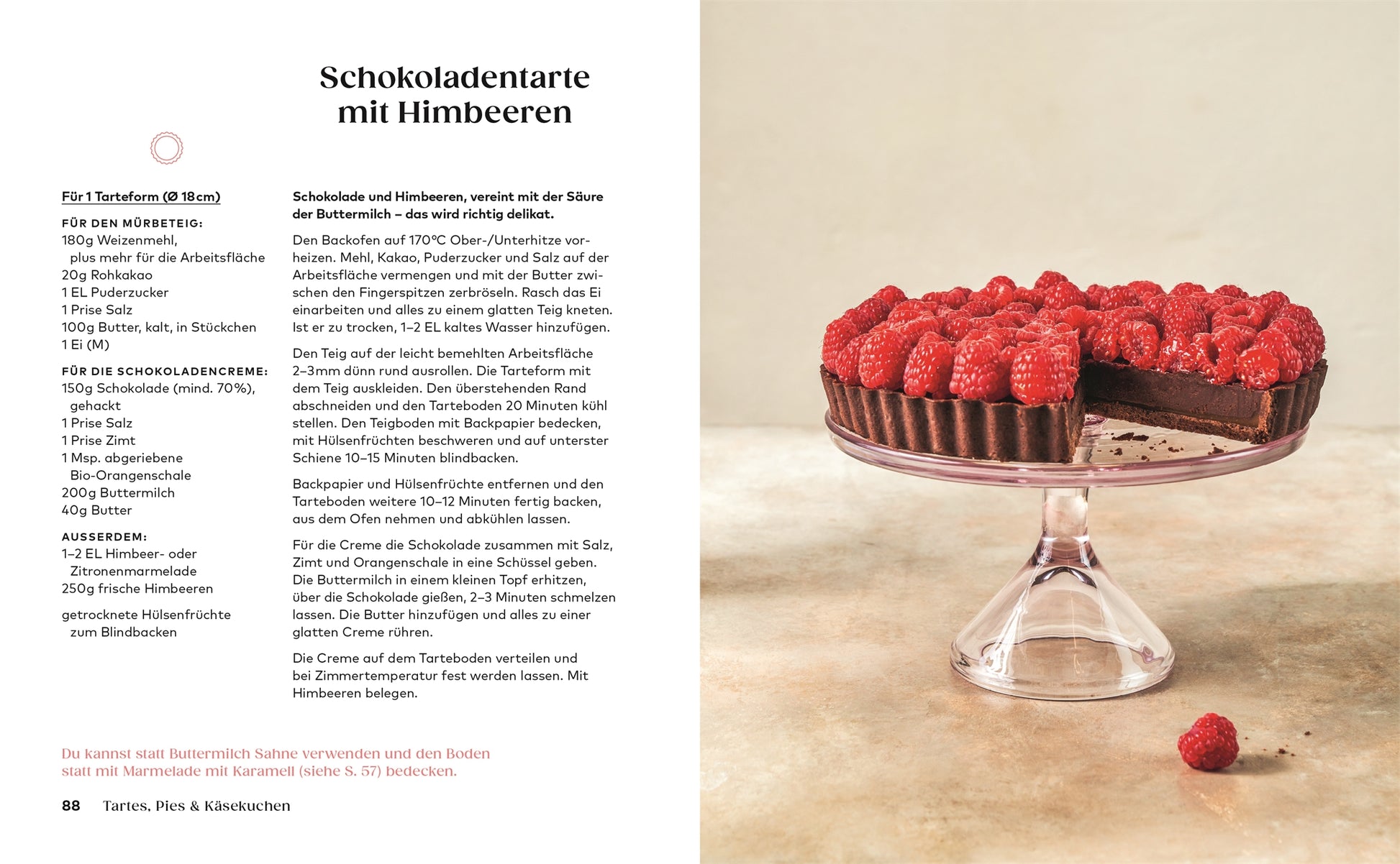 Eine Schokoladentorte von Kleine Kuchen aus dem DK Verlag, belegt mit Himbeeren, steht auf einem Glasständer mit einem Stück daneben. Die dunkle, cremige Torte mit Kruste ist ideal für Fans von veganen und glutenfreien Kuchen. Der Rezepttext erscheint auf der linken Seite.