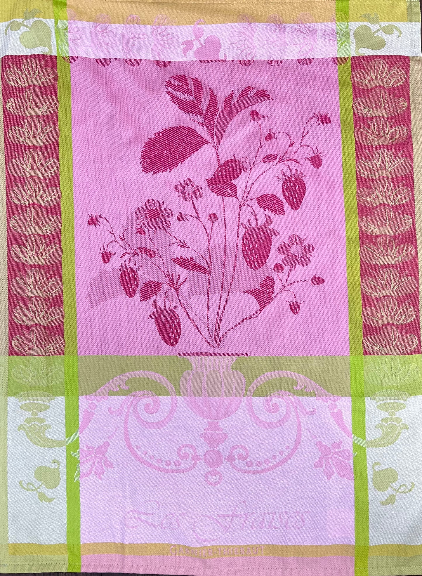 Das Garnier Thiebaut Küchenhandtuch Fraisier zeigt eine Erdbeerpflanzenillustration mit Beeren und Blättern, Rosa- und Goldtönen, grünen und goldenen Rändern, Blumenmustern und „Les Fraises“ am unteren Rand.