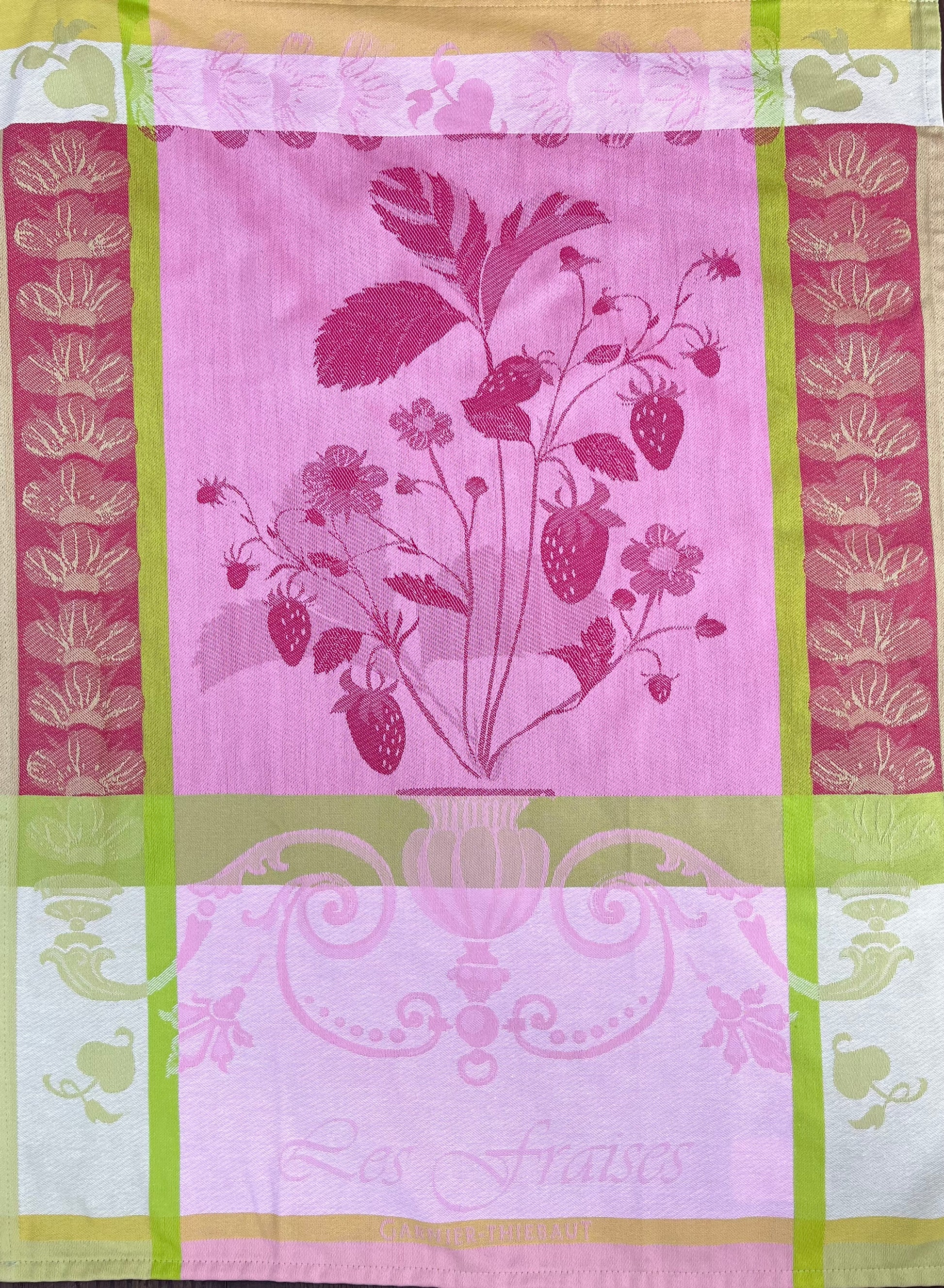 Das Garnier Thiebaut Küchenhandtuch Fraisier zeigt eine Erdbeerpflanzenillustration mit Beeren und Blättern, Rosa- und Goldtönen, grünen und goldenen Rändern, Blumenmustern und „Les Fraises“ am unteren Rand.