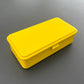 Die Niwaki T-Type Toolbox ist eine rechteckige gelbe Box mit abgerundeten Ecken und einem Frontriegel, perfekt als Werkzeugbox für Gärtner und Handwerker.