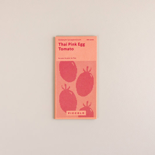 Ein Päckchen Piccolo Seeds - Tomaten-Thai-rosa Ei von Piccolo Seeds, mit einem minimalistischen rosa-roten Design mit drei Tomaten-Illustrationen und Text über diese einzigartige südostasiatische Tomatensorte.