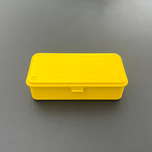 Die Niwaki T-Type Toolbox ist eine kleine, rechteckige, gelbe Werkzeugkiste mit passendem Deckel, ideal für Gärtner und Handwerker. Hier ist sie auf einer dunklen, glatten Oberfläche abgebildet.