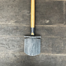 Lade das Bild in den Galerie-Viewer, Der Krumpholz Damenspaten &#39;Elke&#39; (85cm) mit Holzgriff liegt flach auf dunklem Holzboden, das Spatenblatt zeigt nach unten und der Griff ragt aus dem Bild heraus.
