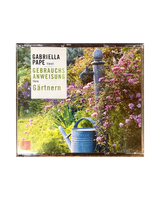 Eine blühende Gartenszene mit rosa Blumen, einer Metallgießkanne und einer alten Wasserpumpe. Umschlagtext: Gabriella Pape - Gebrauchsanweisung fürs Gärtnern | 7 Jahreszeiten, Praxis & Tipps Hörbuch.