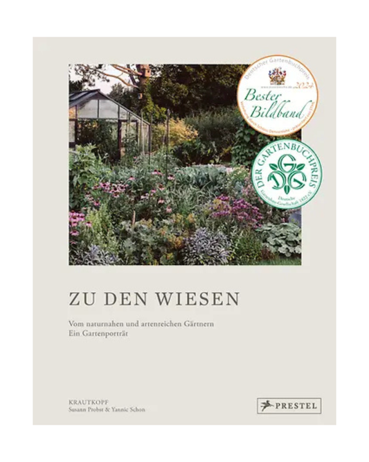Das Cover von Zu den Wiesen | Wunderschöner Foto-Streifzug durch ein Gartenparadies aus dem Prestel Verlag zeigt einen üppigen Naturgarten mit leuchtenden Blüten, zwei Plaketten und ist ein Muss für Gartenbuch-Fans.