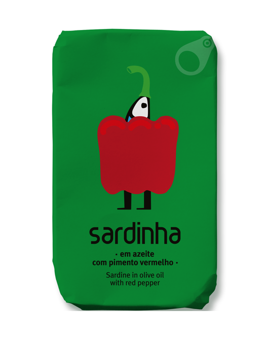 Eine grüne Verpackung zeigt eine Cartoon-Sardine hinter einer roten Paprika mit dem Text "Sardinha - Sardine in Bio-Olivenöl mit Bio-Roter Paprika". Diese Sardine der Marke Sardinha ist reich an Omega 3 und verwendet Bio-Olivenöl.