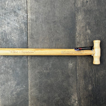 Lade das Bild in den Galerie-Viewer, Ein Krumpholz Damenspaten &#39;Elke&#39; 85cm mit einem hölzernen T-förmigen Griff und einem kleinen schwarzen Etikett in der Nähe des Griffs wird auf einem dunklen Holzboden ausgestellt.
