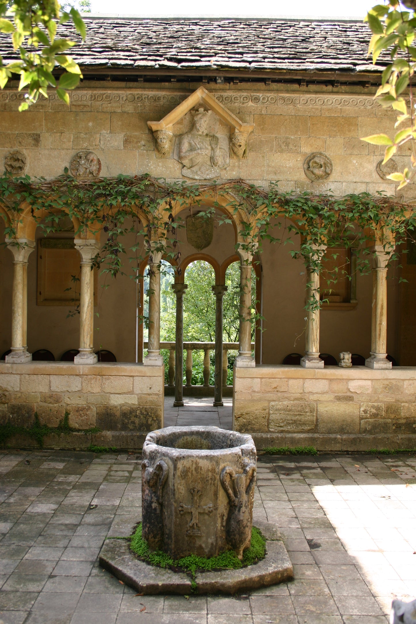 Ein steinerner Innenhof mit moosbewachsenem Brunnen und Laubbögen erinnert an den Charme der Gärten Südenglands - ideal für Dr. Isabelle Van Groeningens AFTERNOON-TEA-VORTRAG "Die Gärten von Somerset, Dorset und Wiltshire" am Di. 17.03.2026, 14:30-15:30.