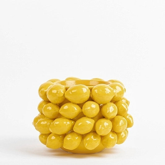 Der Blumentopf von Des Pots besticht mit gelben, plastischen Zitronenmotiven und verleiht dem weißen Hintergrund mediterrane Eleganz.