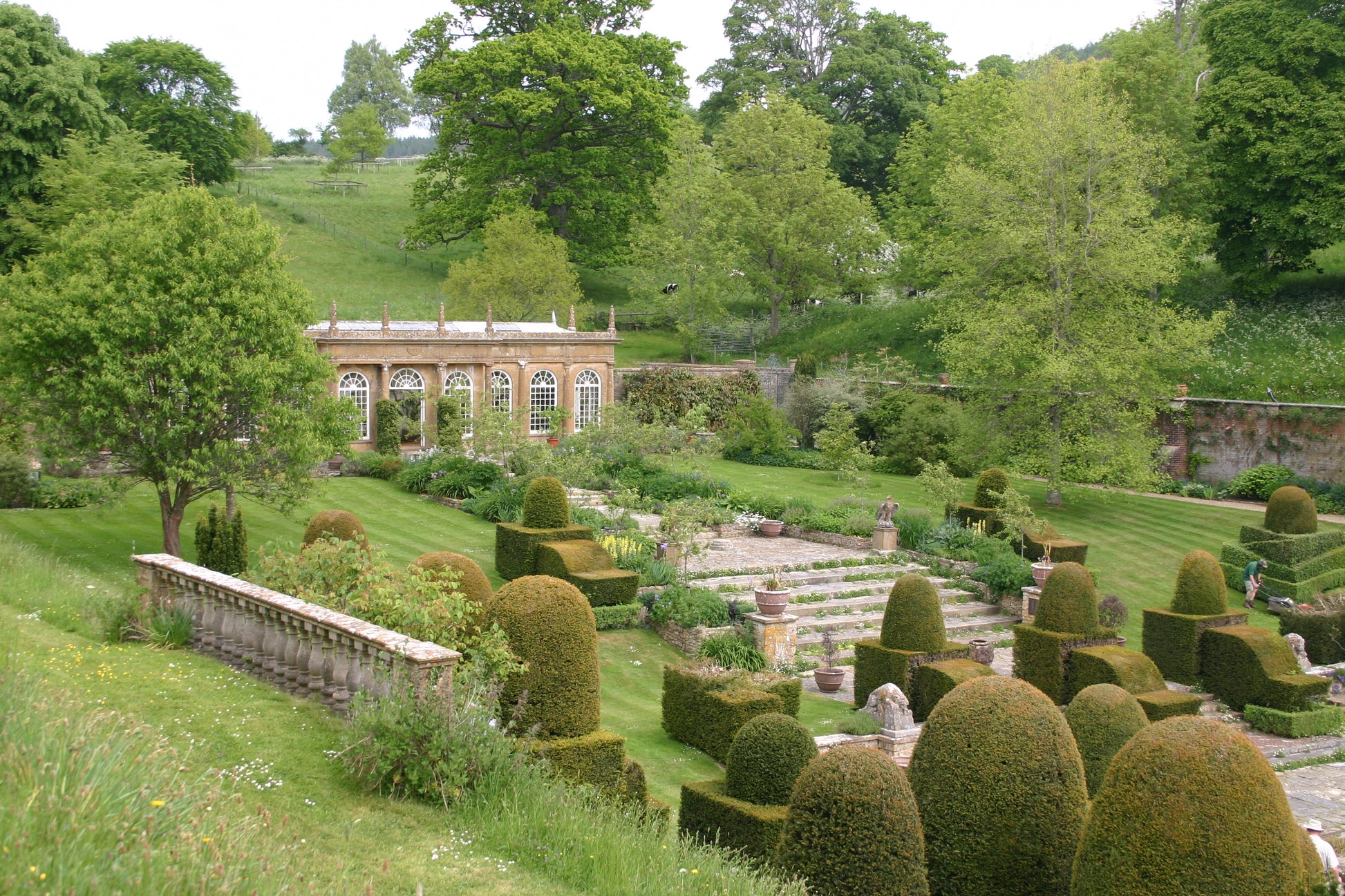 Ein formaler Garten mit Formschnitt, terrassierten Rasenflächen und einem gläsernen Wintergarten erinnert an die Landschaften, die in Dr. Isabelle Van Groeningens Di. 17.03.2026 | 14.30-15.30 AFTERNOON-TEA-VORTRAG: Die Gärten von Somerset, Dorset und Wiltshire.