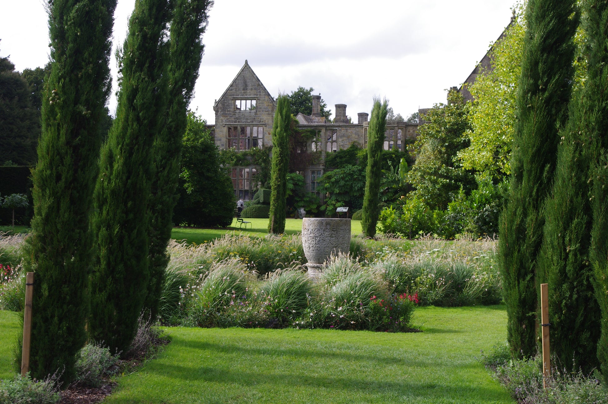 Erleben Sie die Schönheit der Gärten von Kent und Sussex - hohe Zypressen, gepflegte Rasenflächen, steinerne Pflanzgefäße und historische Architektur - bei "Di. 17.02.2026 | 14.30-15.30 AFTERNOON-TEA-VORTRAG Die Gartenpracht von Kent und Sussex" von Dr. Isabelle Van Groeningen.