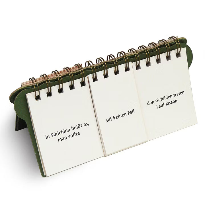 Der Taschentherapeut von Ratschlägen für alle Lebenslagen ist ein Flip-Buch-Kalender mit drei Panels. Er zeigt den deutschen Text: In Südchina heißt es, man sollte auf keinen Fall den Gefühlen freien Lauf lassen. Der Kalender steht auf grünem, dreieckigem Sockel.
