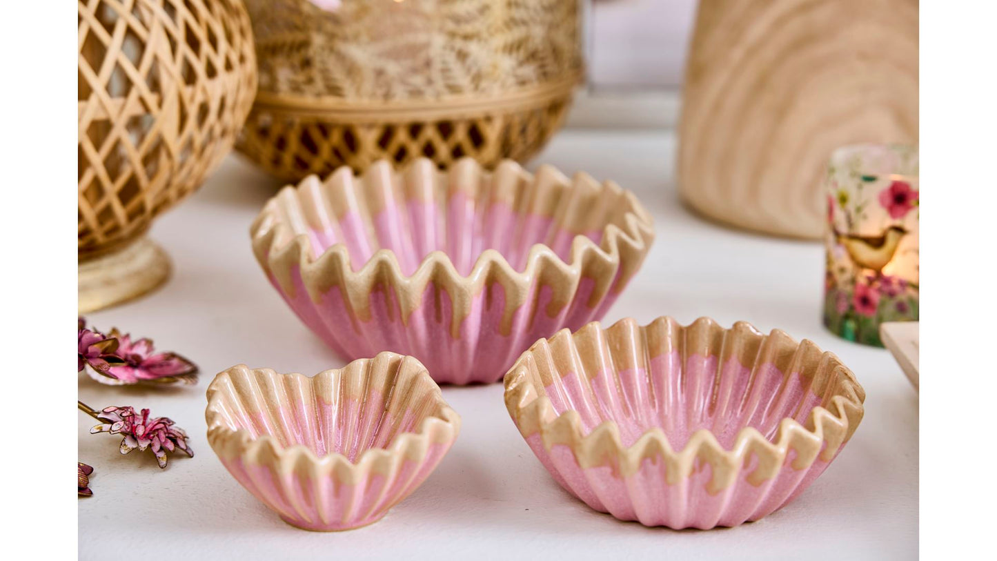 Drei kleine rosa Schalen 'Wave' von 2 Have (5 x 10 cm) stehen auf einer weißen Oberfläche. Im Hintergrund sind dekorative Körbe und getrocknete Blumen arrangiert.