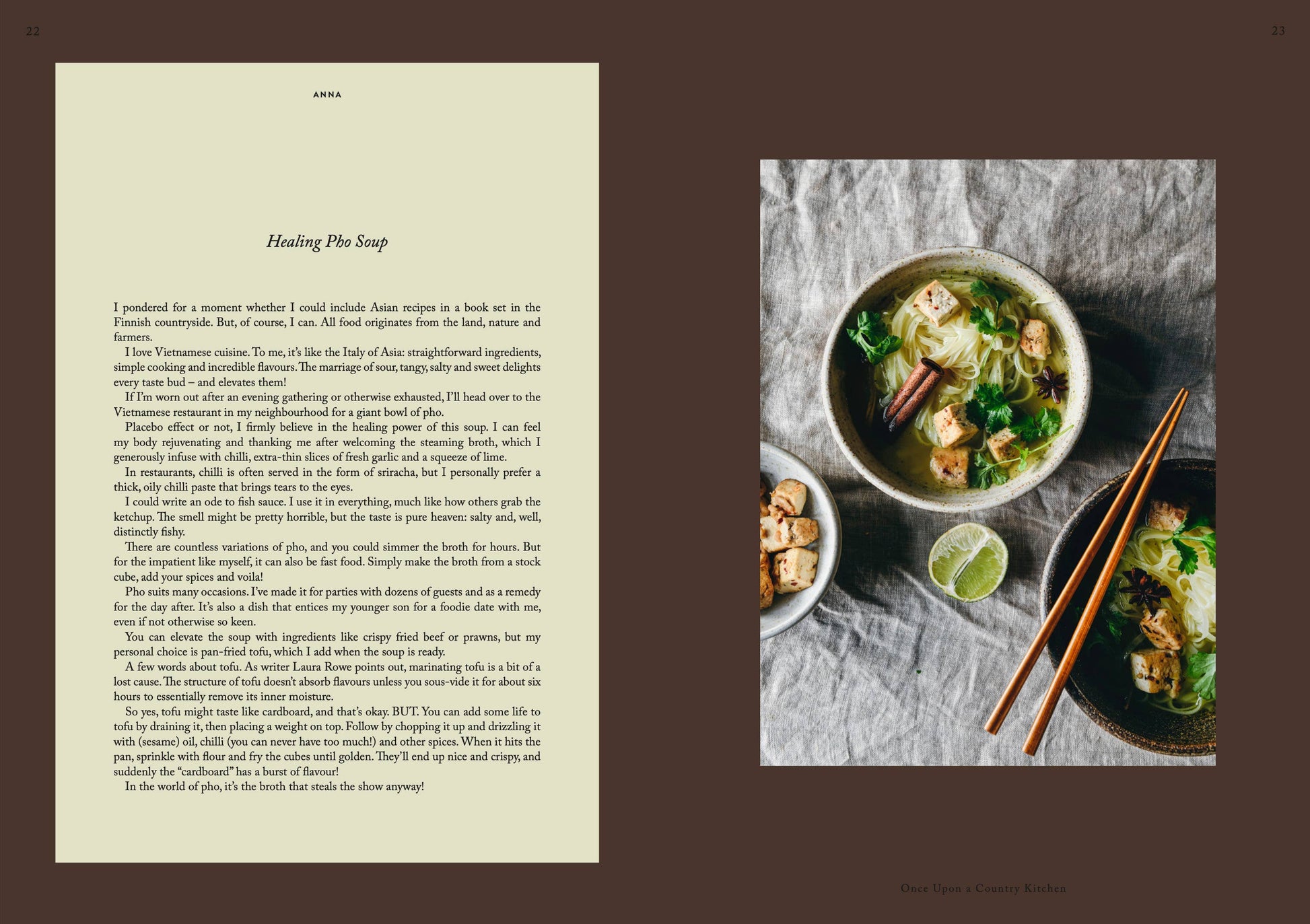 Eine Schüssel Pho mit Tofu, Nudeln, Pilzen und Kräutern steht neben Essstäbchen und einer Serviette und verströmt rustikalen Charme – eine Szene, die von „Once Upon a Country Kitchen“ von Cozy Publishing inspiriert ist.