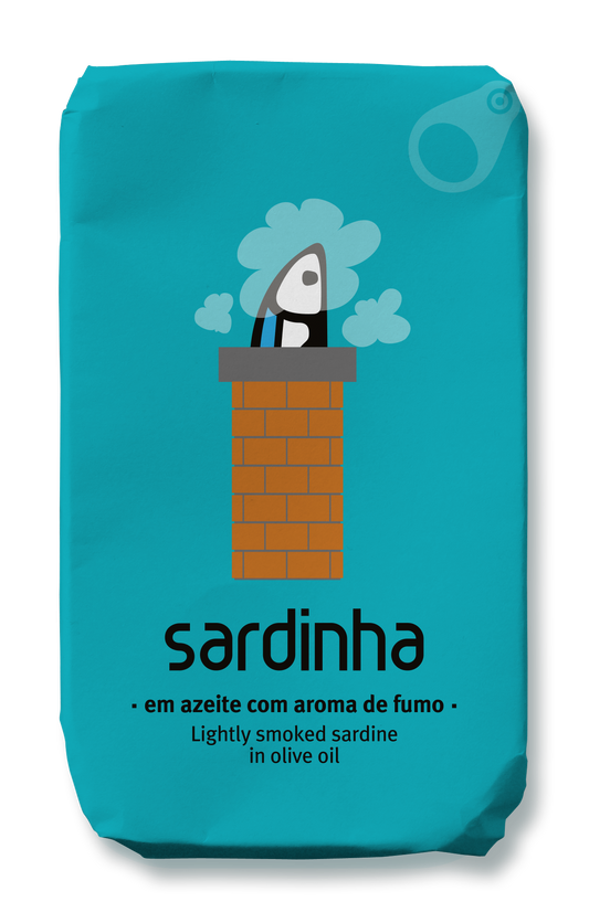 Ein türkisfarbenes Etikett für Sardinha's "Sardinha - Sardine in Olivenöl mit Raucharoma" zeigt eine skurrile Sardine, die aus einem gemauerten Schornstein mit Rauch und einem Text, der leicht geräucherte Sardinen in Olivenöl beschreibt, herausspringt.