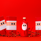 Festliche rote Flasche und drei Schachteln mit minimalistischen Weihnachtsmannmotiven auf leuchtend rotem Hintergrund. yiayia and friends - Natives Olivenöl extra - Weihnachtsedition 500 ml-das perfekte Geschenk für Feinschmecker, umgeben von roten Beeren und Zweigen.