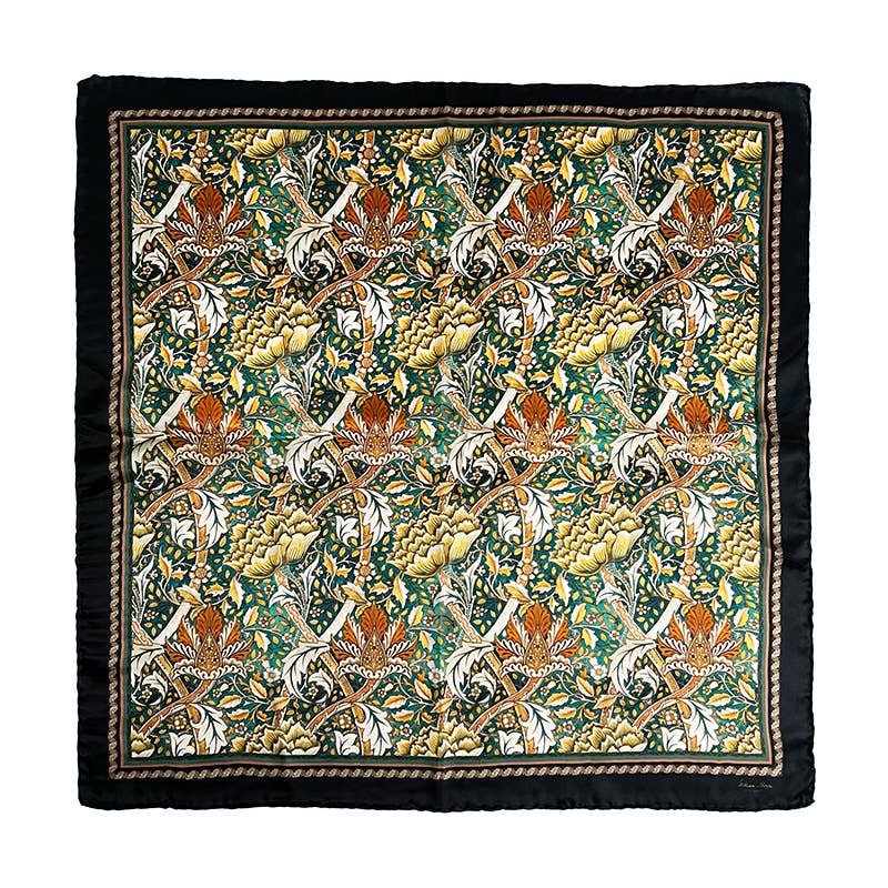 Das Koustrupco Seidenschal Morris Windrush grün (50 x 50 cm) zeigt ein kompliziertes Batikmuster mit Vögeln, Blättern und Blumen in Orange, Grün, Senfgelb und Weiß - umrahmt von einer schwarz-braunen Bordüre für einen luxuriösen Touch.