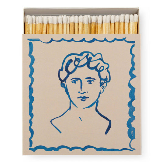 Archivist Gallery - Handsome | Square Sicherheitsstreichhölzer: Eine offene Streichholzschachtel mit Holzstreichhölzern, die eine blaue Strichzeichnung eines wellenförmigen Kopfes mit einem gewellten Rand zeigt - charmant und stilvoll von Archivist Gallery.