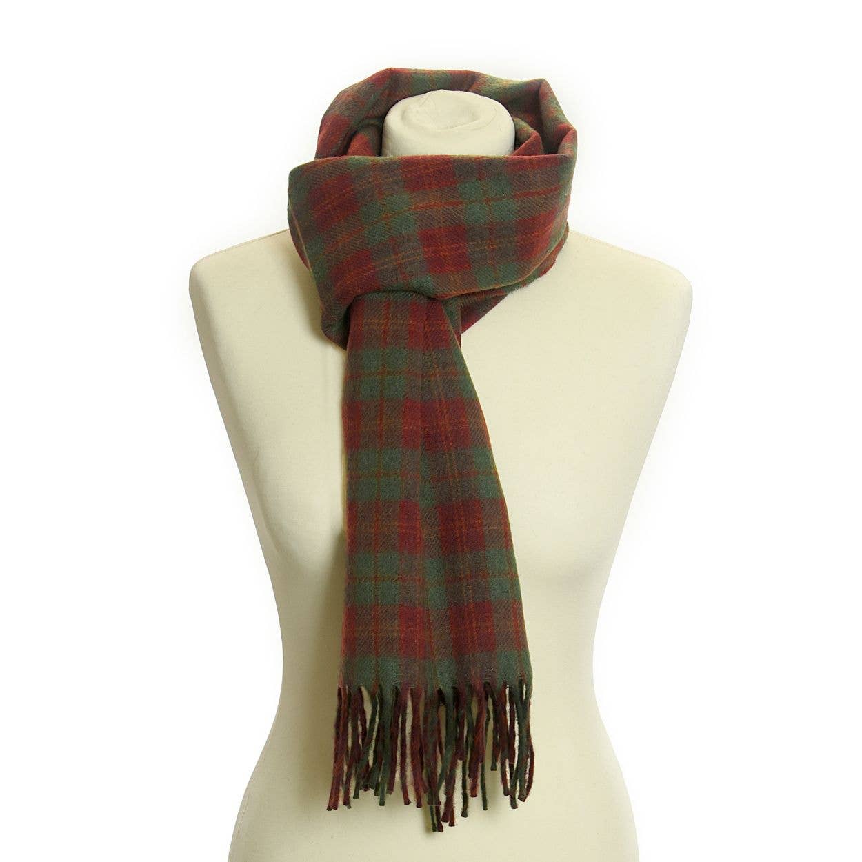 Eine Schaufensterpuppe zeigt den Lammwoll-Landkaro-Schal von Tweedmill Textiles in Grün und Rot, um den Hals drapiert und mit Fransen an den Enden. Hergestellt aus 100% Lammwolle von Tweedmill Textiles, bietet dieser Schal ultimative Weichheit und Wärme.