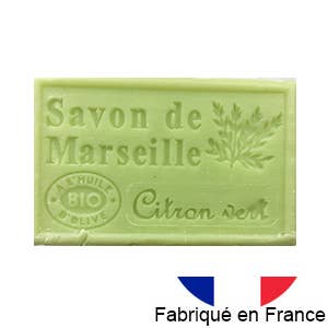 Eine hellgrüne Tafel von Dampa 1975 - Marseiller Seife mit Bio-Olivenöl-Limettenduft zeigt eine Pflanzenillustration, Limette Duft, und eine kleine französische Flagge mit dem Text "Fabriqué en France" darunter.