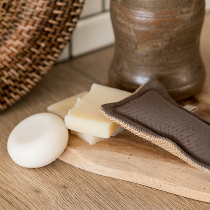 „A Simple Things – Waschbarer Schwamm | Die Scharfen“ liegt auf einem Holztablett neben einem Keramikbehälter und einem geflochtenen Korb auf einer hellen Holzoberfläche.