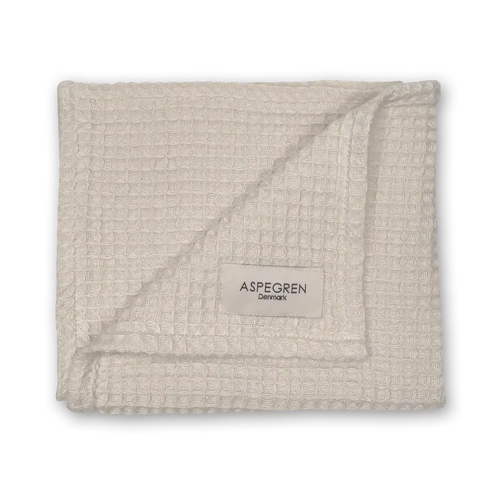 Das Aspegren Denmark Geschenkset Praliné enthält ein beiges, waffeltexturiertes Tuch mit Label - stilvoll, nachhaltig und ideal als Geschirrtuch oder als Teil eines Küchen-Geschenksets.