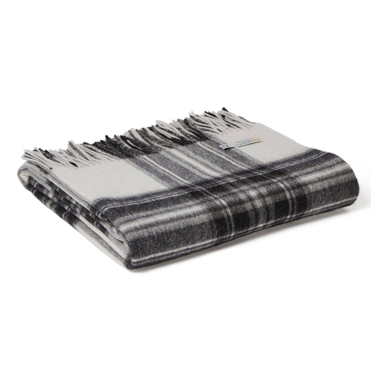 Eine Tweedmill | Lammwoll-Tartan-Decke von Tweedmill Textiles mit schwarzem, weißem und grauem Schottenkaro und ausgefransten Rändern ist gefaltet und ordentlich auf einem weißen Hintergrund gestapelt.