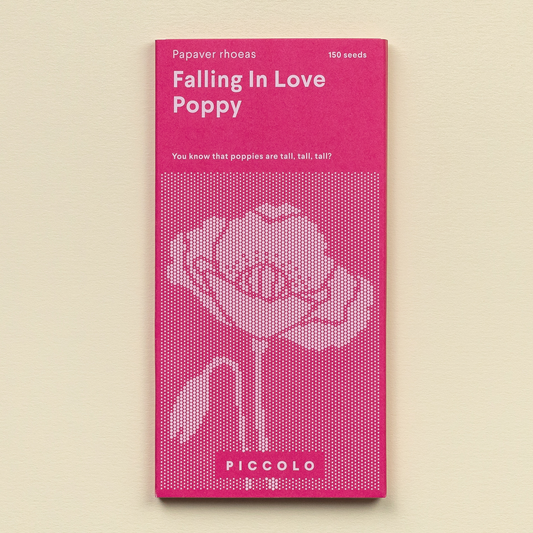 Ein rosa Päckchen mit der Aufschrift „Piccolo Seeds – Poppy Verliebt sich“ zeigt eine gepunktete Mohnblumenillustration, weist darauf hin, dass es 150 Samen enthält, trägt unten die Marke Piccolo Seeds und ist ideal für Zierzwecke.