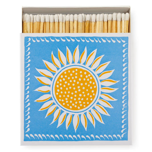 Die Archivist Gallery - Ariana Sunflower | Square Sicherheitsstreichhölzer haben eine blaue Schachtel mit einem dekorativen gelben und weißen Sonnenblumendesign, ideal, um Ihrem Weihnachtssortiment ein besonderes Flair zu verleihen. Marke: Archivist Gallery.